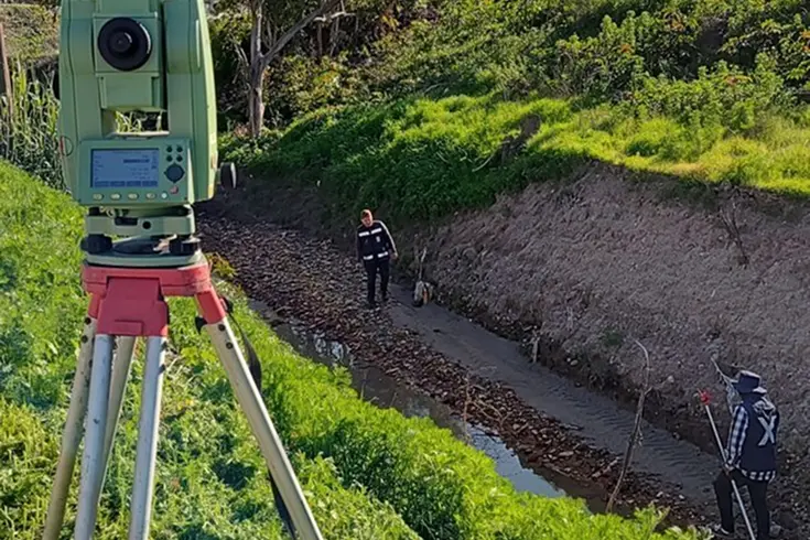 Equipo de topografía realizando un levantamiento en un predio de Cali